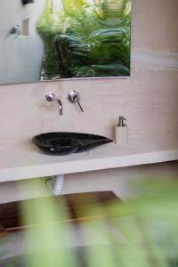 een badkamerbar met een wastafel en een spiegel bij Villa Yahualli in #N/A