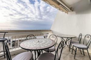 uma varanda com mesas e cadeiras e vista para o oceano em Le Saint Clair - maeva Home - Appartement 3 pièces 6 personnes - Prestige 004 em La Grande-Motte