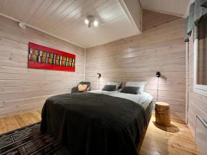 a bedroom with a bed and a red painting on the wall at Log cabin in 15 min from Rovaniemi center- 3bdr-Sauna-Fireplace in Rovaniemi