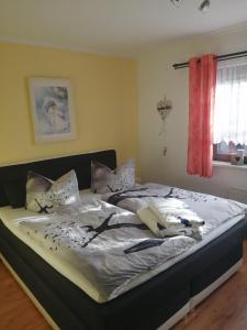 een slaapkamer met een bed met witte lakens en kussens bij "Kleine Hedwig" in Putbus