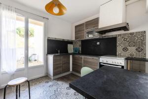 een keuken met een zwart aanrecht en een raam bij Haute Plage - maeva Home - Maison 5 pièces 8 personnes - Prestige 214 in La Grande-Motte