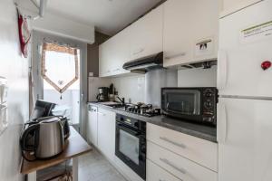 eine kleine Küche mit einer Mikrowelle und einem Kühlschrank in der Unterkunft Le Grand Voilier - maeva Home - Studio 4 personnes - Sélection 234 in La Grande-Motte