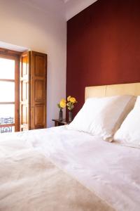 een slaapkamer met een wit bed en een bruine muur bij Alojamiento Yecla Centro by piso del Ayuntamiento de Yecla in Yecla