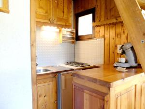 a kitchen with wooden cabinets and a stove top oven at Chalet Neve - Studio pour 4 Personnes 814 in Tignes