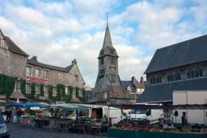 un mercado en una ciudad medieval con una torre de reloj en Le Balcon du Port, en Honfleur