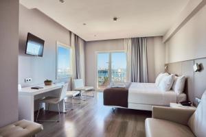 a hotel room with a bed and a desk at Silken Turcosa in Castellón de la Plana