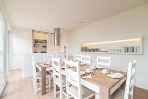 a kitchen and dining room with a wooden table and chairs at Azoriani City Hostel Ponta Delgada in Ponta Delgada