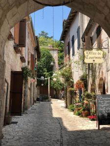 eine Gasse in einer Altstadt mit einem Torbogen in der Unterkunft Charmant T2 chambre lit double dans résidence du Lac in Monflanquin