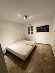 1 dormitorio con 1 cama blanca en una habitación en Quai Saint Louis - maeva Home - Villa 4 pieces 6 personnes - Prestige 544, en Aigues-Mortes