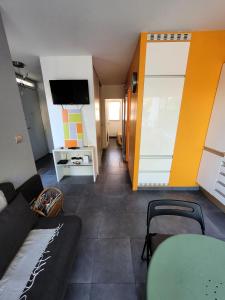 ein Wohnzimmer mit einem Sofa und einem TV in der Unterkunft Le Birdy - maeva Home - Appartement 2 pièces 4 personnes - Prestige 614 in La Grande-Motte