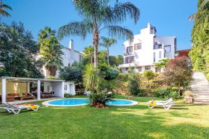 een huis met een tuin met een zwembad bij Villa Jazminez by Villa Plus in Marbella