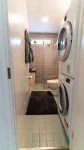 a bathroom with a washer and dryer next to a toilet at Spacious 68m2 apartment with fabulous forest view in Järvenpää
