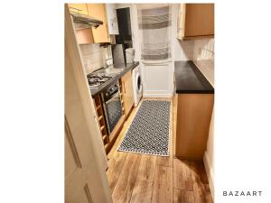 a kitchen with a stove and a kitchen rug at Spacious 3-Bed House with free parking in Hornchurch