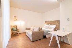 a bedroom with a bed and a couch and a table at Azoriani City Hostel Ponta Delgada in Ponta Delgada