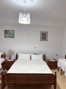 a bedroom with a large bed with white sheets at Tourists Guest House in Gjirokastër