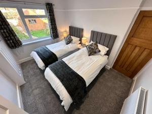 two twin beds in a room with two windows at City centre home in Canterbury with free parking in Canterbury