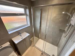 ein Bad mit einer Dusche und einem Waschbecken in der Unterkunft City centre home in Canterbury with free parking in Canterbury