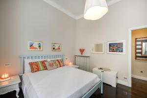 een witte slaapkamer met een bed en twee nachtkastjes bij Casa Venus in La Spezia