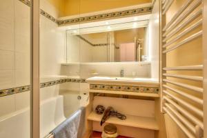 łazienka z wanną, umywalką i lustrem w obiekcie Village Pont Royal en Provence - maeva Home - Appartement cosy et climatisé 2 pièces 5 personnes avec jardin - Prestige - super Home MAE-2864 w mieście Mallemort