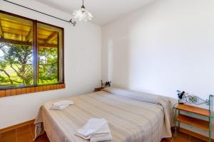 1 dormitorio con cama y ventana en Villa due Archi, en S'Archittu