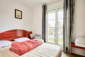 a bedroom with a large bed and a large window at Les maisons de Port Guillaume - maeva Home - Maison 3 pièces 6 personnes - Confort MAE-3464 in Dives-sur-Mer