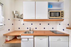 a small kitchen with a sink and a microwave at Les maisons de Port Guillaume - maeva Home - Maison 3 pièces 6 personnes - Confort MAE-3464 in Dives-sur-Mer