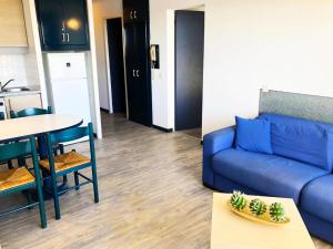 salon z niebieską kanapą i stołem w obiekcie Résidence Le Boucanier - 3 Pièces pour 6 Personnes 904 w mieście Vieux-Boucau-les-Bains