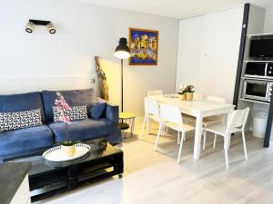 salon z niebieską kanapą i stołem w obiekcie Résidence Le Boucanier - 3 Pièces pour 6 Personnes 954 w mieście Vieux-Boucau-les-Bains