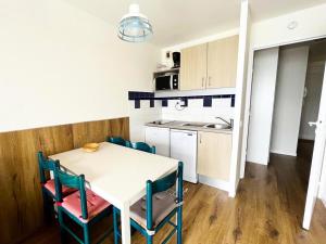kuchnia i jadalnia ze stołem i krzesłami w obiekcie Résidence Le Boucanier - 2 Pièces pour 6 Personnes 964 w mieście Vieux-Boucau-les-Bains