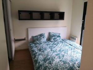 Schlafzimmer mit einem Bett mit blauer Bettwäsche und Kissen in der Unterkunft Maison de 2 chambres a Le Conquet a 200 m de la plage avec wifi in Le Conquet