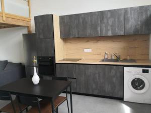 une cuisine avec une table et une machine à laver dans l'établissement Appartement accueillant au cœur de Le Conquet avec parking privé, au Conquet 3 autres photos