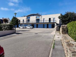 un bâtiment avec deux voitures garées dans un parking dans l'établissement Appartement accueillant au cœur de Le Conquet avec parking privé, au Conquet
