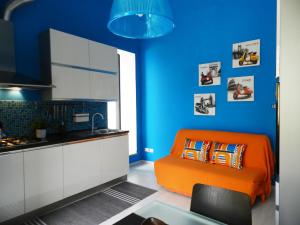 an orange couch in a kitchen with a blue wall at Dea Cibele in Rome