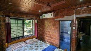 a small bedroom with a bed and a window at Tiny Waves in Udupi