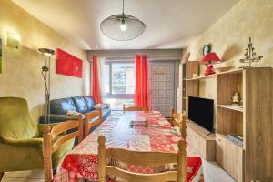 a living room with a dining room table and a television at Le koala in Villard-de-Lans