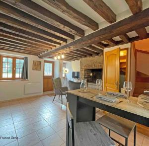 cocina y sala de estar con mesa y sillas en Le p’tit Suisse Normand en Putanges