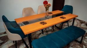a wooden table with chairs and a vase with flowers on it at QPT 