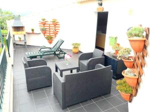 un patio con sillas, mesas y macetas en One bedroom appartement with terrace and wifi at Santana 5 km away from the beach, en Santana