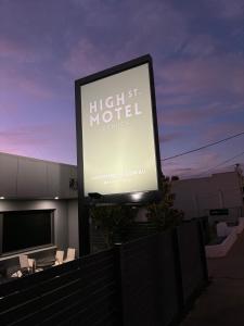 un gran cartel para un hotel con un edificio en High Street Motel, en Echuca
