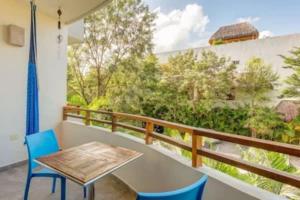 uma varanda com uma mesa e cadeiras e uma vista em Condo Complex with an Alluring Pool & Tropical Vibes by Stella Rentals em Tulum