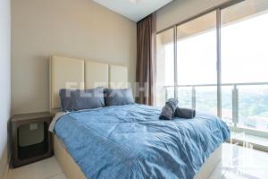 - une chambre avec un lit bleu et une grande fenêtre dans l'établissement Dorsett Residences, Sri Hartamas-KL, Hotel Theme Studio Homes by Flexihome-MY, à Kuala Lumpur