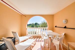 Zimmer mit weißen Stühlen, einem Tisch und einem Fenster in der Unterkunft Résidence les Calanques des Issambres - maeva Home - Appartement 2 pièces 4 personnes - Sélection MAE-3624 in Les Issambres