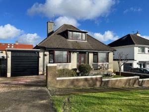 a white house with a black garage at Bungalow Three Bedroom The Park Onchan Isle of Man in Onchan