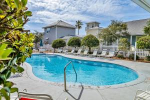 a swimming pool with lounge chairs and a house at Cottages of Crystal Beach Sea La Vie in Destin