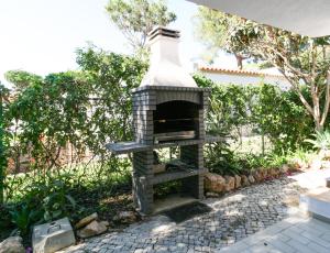 ヴィラモウラにあるFLH Villa Orquídea Vilamoura with Poolの庭園(パティオ付)のレンガ造りのオーブン