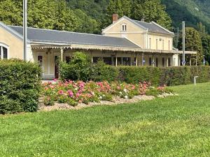 a house with a garden of flowers in front of it at Palais d'étigny in Luchon