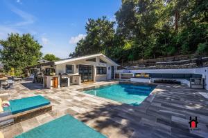 Un patio trasero con piscina y una casa. en Resort Feel I Breathtaking Mountain Scenery I Pool, en Malibú