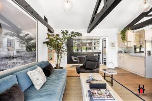 Una sala de estar con un sofá azul y una cocina. en Resort Feel I Breathtaking Mountain Scenery I Pool, en Malibú