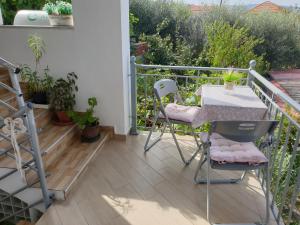 patio ze stołem i krzesłami na balkonie w obiekcie Bei Kosta w mieście Mesopótamon