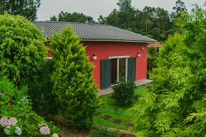czerwony dom z drzewami przed nim w obiekcie Spacious House in Santana with Terrace and Parking Included w mieście Santana